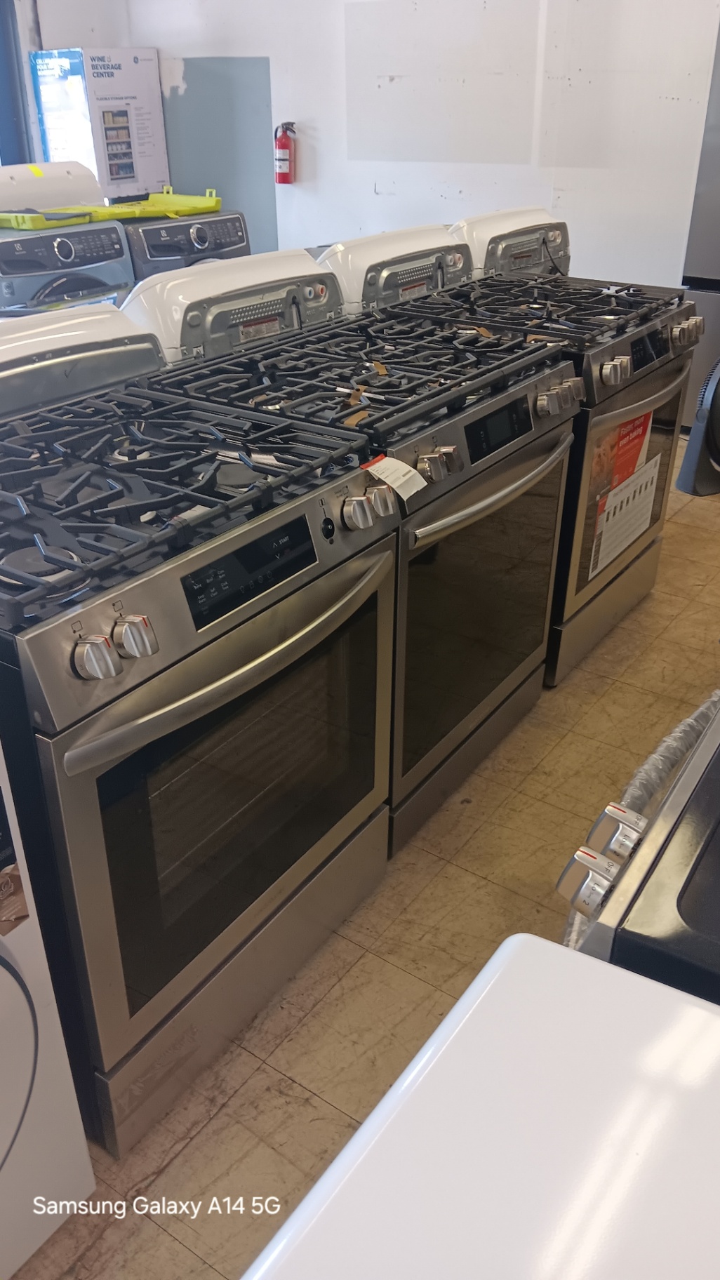 Row of stainless steel gas ranges on the showroom floor